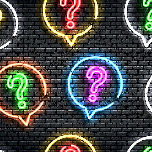 The image shows colorful neon question marks inside speech bubbles on a dark brick wall backdrop.