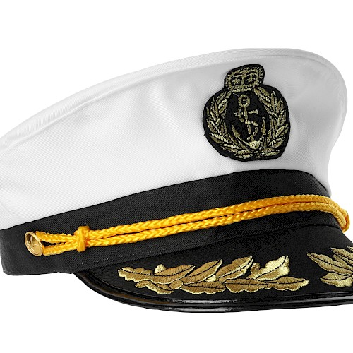 The image shows a white naval captain's hat with a gold emblem and braided decoration on the black brim, featuring an anchor motif.
